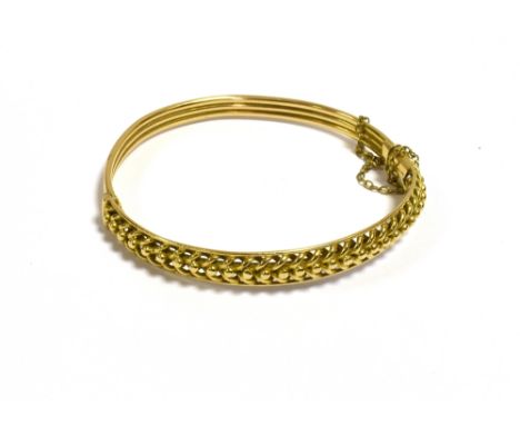 9CT GOLD HINGED BANGLE  6.9mm wide, plaited wire work front, with hinge to one side and three plain wires to reverse, push in