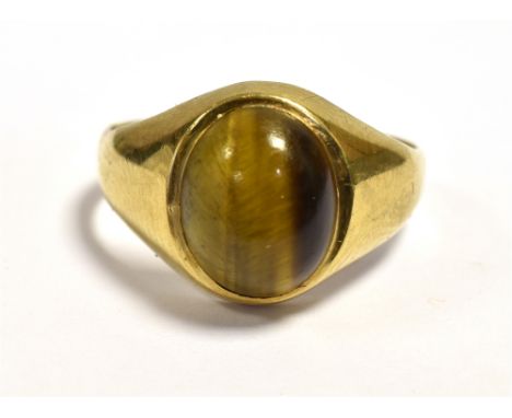 A 9CT GOLD TIGERS EYE RING  Set with a 9.9 x 8.2mm oval tigers eye cabochon with integral shank, ring size K.  Hallmarked 9.3