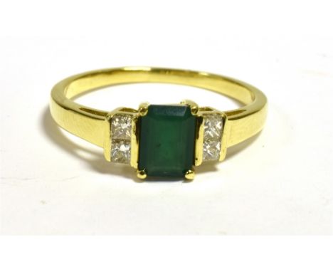 18CT GOLD EMERALD &amp; DIAMOND RING  With central octagonal step cut emerald, estimated 0.61 carats flanked by channel set p