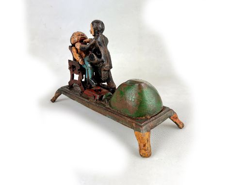 This Vintage Dentist Mechanical Coin Bank is a unique and whimsical cast iron toy bank, likely dating back to the late 19th o