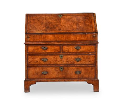 A QUEEN ANNE WALNUT BUREAUEARLY 18TH CENTURYThe fall enclosing drawers, pigeon holes and a slide over the well103cm high, 99c