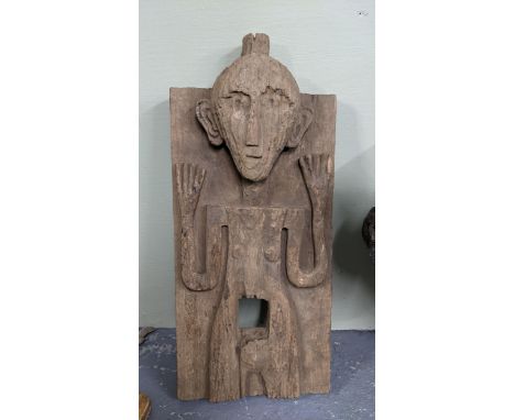 An Indonesian hardwood tribal carved small door carved in relief depicting a figure with raised arms 68cm h x 30.5cm w Locati