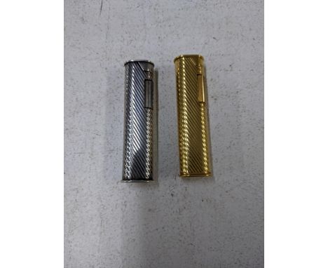 A pair of retro Dunhill slim roller style gas cigarette lighters in gold and silver colours, with engine turned casesLocation