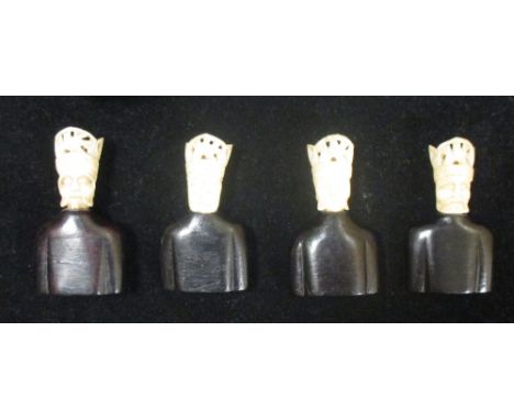 Four wooden busts with bone crowned heads, possibly menu or place name holders  