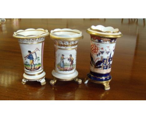 Three wavy rimmed spill vases, each on three paw feet, two painted with hay workers, 15cm high and the Spode decorated in the