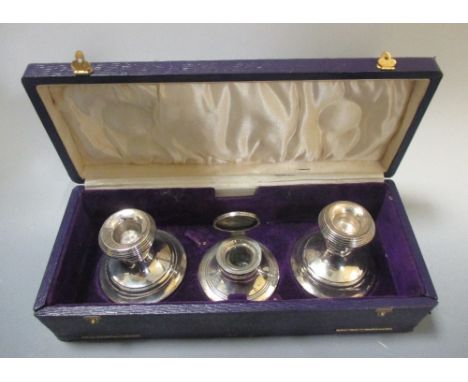 A pair of silver dwarf candlesticks, D&W, Birmingham, cased together with a matching capstan inkwell  