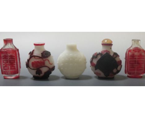 A white glass snuff bottle together with four ruby overlay glass snuff bottles  