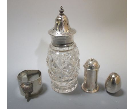 Three small silver pepper casters (one with a glass body) and a napkin ring  