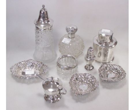 A silver tea caddy flask, pepper caster, glass sugar shaker with silver top, three pierced silver bon bon dishes, a scent bot