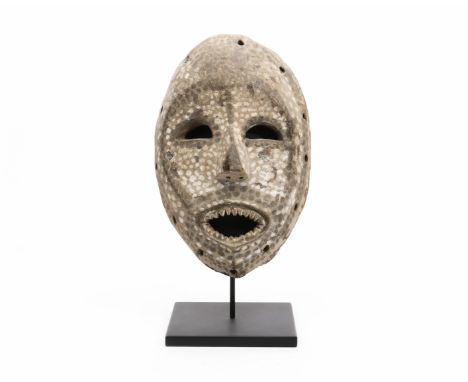 D. R. Congo, Ituri, face mask, with pierced eyes and mouth, showing carved teeth, the face showing a dotted pattern in white 