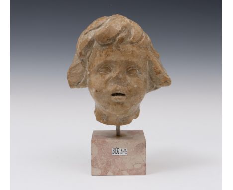 An antique marbel buste, with remnants of a pigment layer and at the backside a protrusion, possibly once part of a larger fi