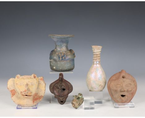 An antique terracotta head of a bull and a bronze antique fragment of a bull. Herewith two glass bottles, a terracotta face a