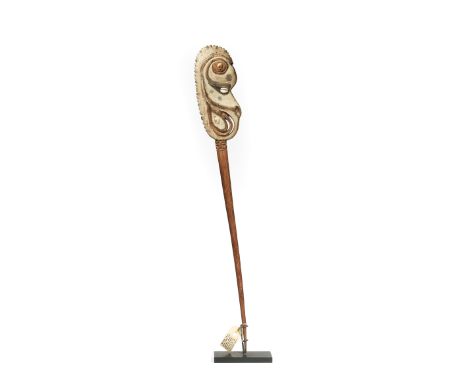 P.N. Guinea, Lower Sepik, lime stick, surmounted by a zoo- anthropomorphic flat head with shell inlay. H. 56,5 cm. [1]