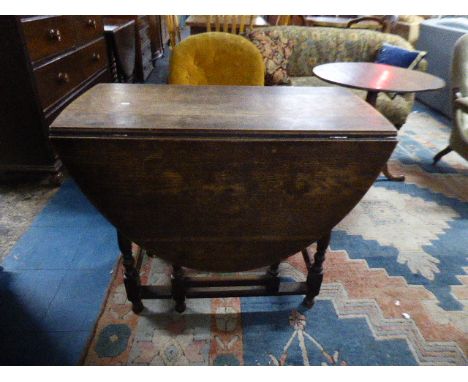 An Oak Drop Leaf Oval Top Gate Legged Dining Table 