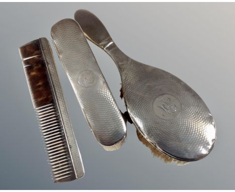 A three piece silver backed dressing table brush and comb set