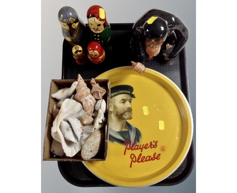 A tray of ceramic figure of a monkey, Russian dolls, sea shells and a Player's Please tin tray 