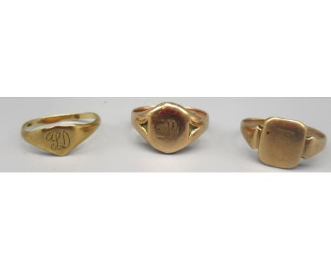 9ct yellow gold signet ring, the oval face engraved EW, size K, and two other signet rings, all stamped 9ct, 5.6g 