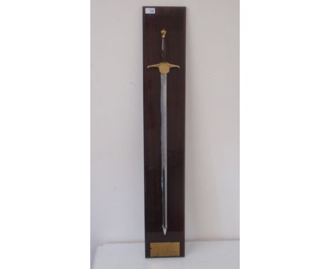 C20th Wilkinson Sword presentation sword with engraved blade, brass cross piece, pommel and turned mahogany grip, numbered 11