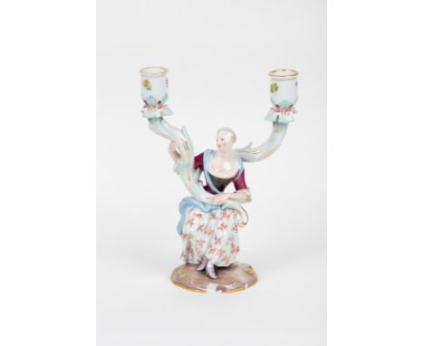 A Meissen figural two-light candelabrum, circa 1860, modelled as a lady supporting two foliate scroll branches, blue crossed 