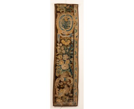 A Flemish rectangular tapestry fragment, ovals of flowers and other decoration and a parrot to the base, 189cm high x 44cm wi