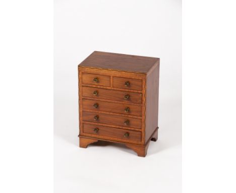 A mahogany apprentice chest with inlaid surround, fitted four long and two short drawers on bracket feet, 37cm wide CONDITION