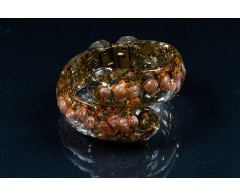 A vintage lucite hinged bangle embedded pink seashells and gold confetti 