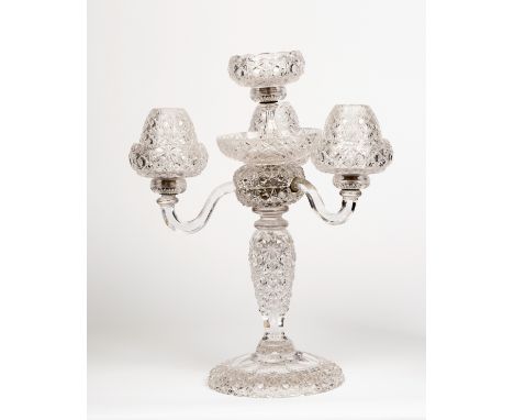 A 1930s cut glass crystal three-branch, four-light table light, with three hexagonal scroll branches and cupped lights on a c