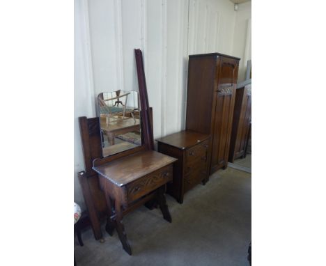 A carved Ipswich oak four piece bedroom suite, comprising; single door wardrobe, chest of drawers, dressing table and a singl