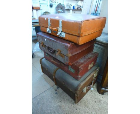 A steamer trunk and three suitcases 