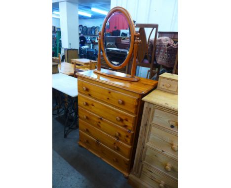 A pine chest of drawers and a toilet mirror 