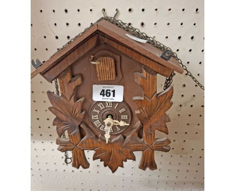A small modern stained wood and resin cased cuckoo clock with acorn pattern weights