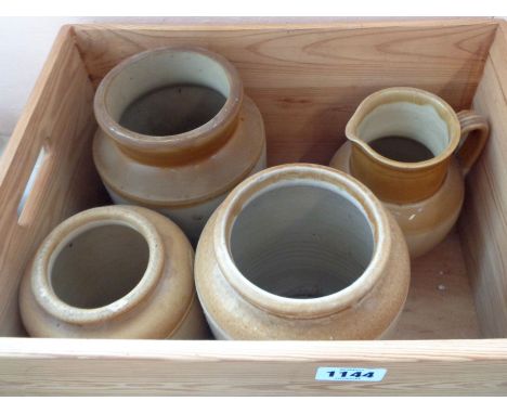 A wooden crate containing a Fulham Pottery Bristol glazed stoneware jug and three similar storage jars