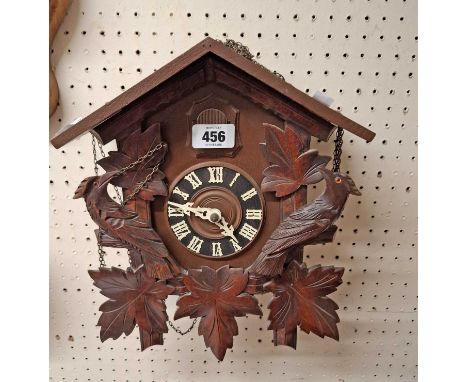 A modern wood and resin cased Black Forest style cuckoo clock with acorn pattern weights