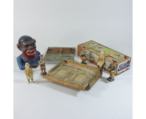 An early 20th century cast iron character money box, 18cm high, together with wooden toy soldiers, two other vintage games an