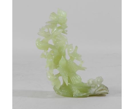 A jade coloured hardstone carving of bird in a tree, 18cm high