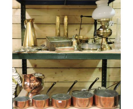 Two shelves of brass and copper items, to include a set of copper saucepans, a converted oil lamp and a warming pan