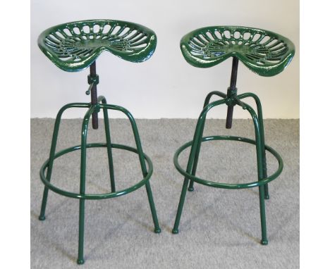 A pair of green painted metal tractor seat bar stools