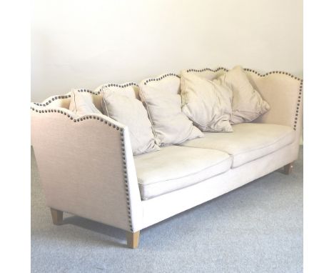 A large modern cream upholstered three seater sofa, with studded upholstery, 235cm