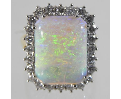 A large 18 carat gold opal and diamond cluster ring, approximately 7.0 carats, surrounded by twenty-four diamonds