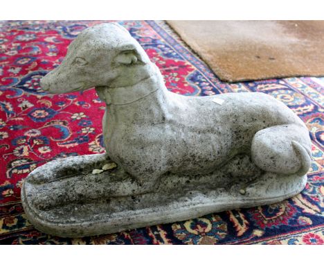 A COMPOSITE STONE GREYHOUND, 61cm wide together with composite stone bench with shaped support, 94cm wide (2)