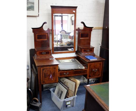 AN EDWARDIAN MAHOGANY DRESSING TABLE the rectangular mirrored plate and raised back over split level top and three frieze dra