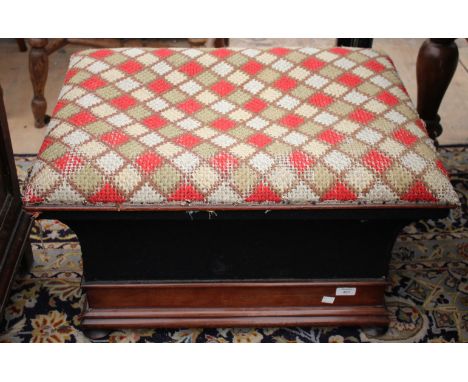 A VICTORIAN MAHOGANY OTTOMAN STOOL the needlework upholstered lid above waisted sides on a mahogany plinth base with turned f