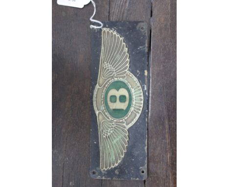 A BLACK PAINTED AND GREEN ENAMEL DECORATED BENTLEY FIREWALL EMBLEM FROM A 1930'S BENTLEY MOTOR CAR 22.8 x 8.2cm 