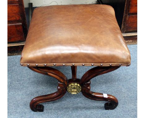 A ROSEWOOD X-FRAMED STOOL with brown leather upholstered seat and scrolling feet, 48cm wide