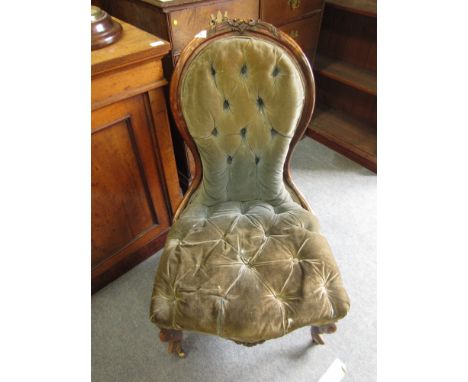 A VICTORIAN WALNUT FRAMED NURSING CHAIR with blue velvet button back upholstery and carved cabriole legs terminating in brass