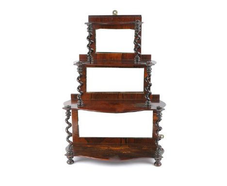 A 19TH CENTURY ROSEWOOD THREE TIER SERPENTINE FRONTED WALL SHELF, each section with a mirrored back and carved spiral support