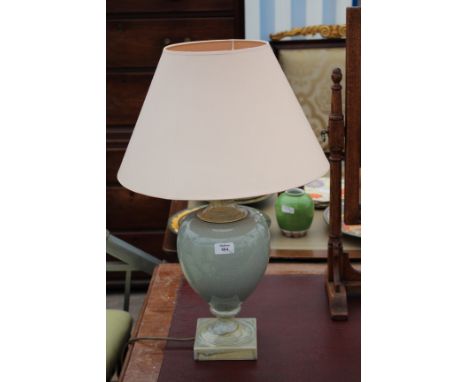 A GREEN GLAZED POTTERY TABLE LAMP of baluster form and standing on square base together with a further glass and brass table 