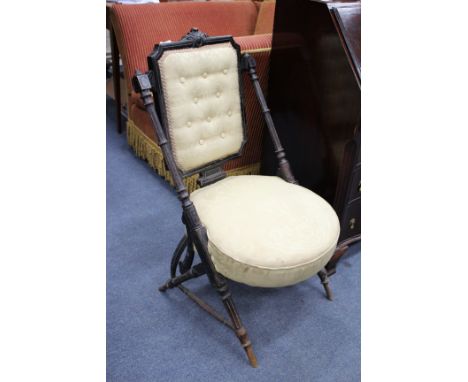 A VICTORIAN EBONISED AESTHETIC CHAIR with rectangular button upholstered inset back, angled turned column supports, overstuff