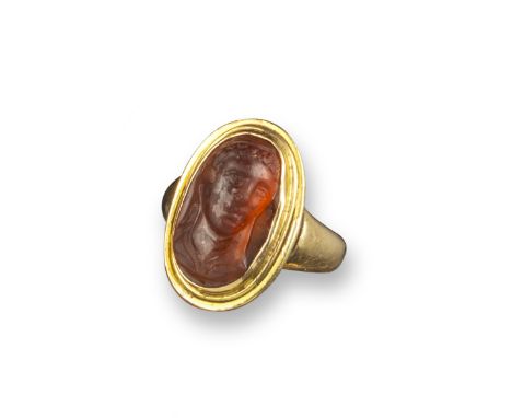 A Hellenistic garnet cameo depicting the head of Omphale, c1st century BC, in an early 19th century gold ring, the cameo 1.6c