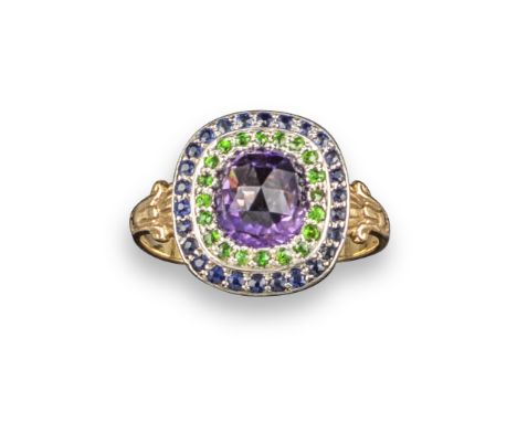 A gem-set cluster ring, centred with a faceted amethyst within a surround of circular-cut green garnets and sapphires, with f